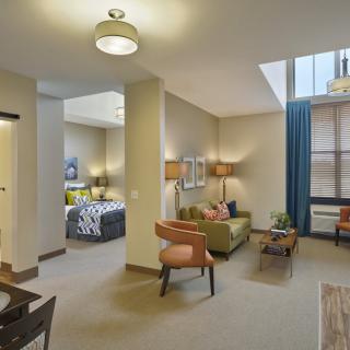 A modern apartment with an open living area featuring stylish furniture and ample natural light.