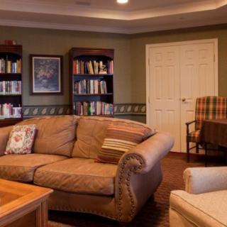 A cozy living room with a comfortable sofa, bookshelves filled with books, and warm lighting.