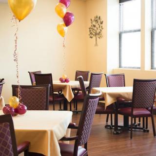 A decorated dining room featuring balloons and neatly arranged tables.