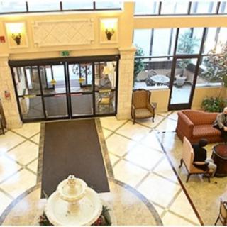 A spacious hotel lobby with a seating area and large glass entrance doors.