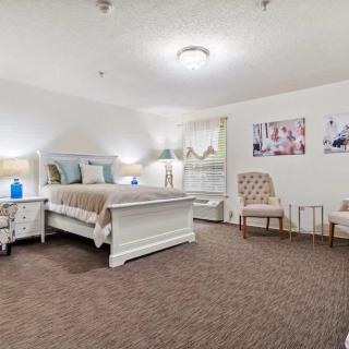 A spacious and elegantly decorated bedroom with a large bed and cozy seating area.