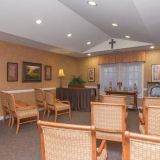 A serene chapel interior with rows of chairs and religious decor.