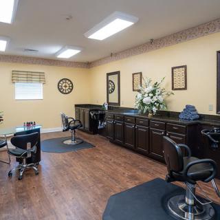 An interior view of a hair salon featuring chairs, mirrors, and wooden flooring.