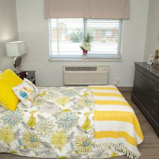 A cozy bedroom with yellow and floral decor accents.