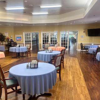 A well-lit dining area with blue tablecloths and a warm ambiance, designed for community gatherings.