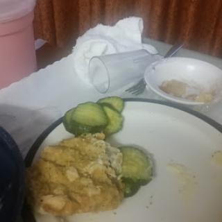 A simple meal featuring some leftovers and cucumber slices on a plate.