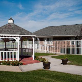 A serene outdoor space featuring a white gazebo surrounded by well-maintained lawns and pathways.