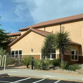 A residential building with desert landscaping and clear skies.