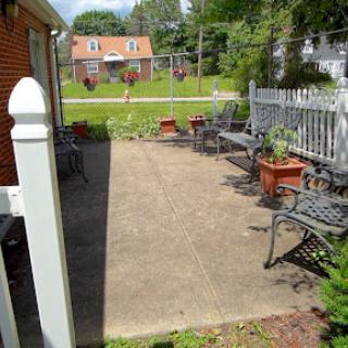 A serene outdoor patio space featuring metal seating and potted plants, ideal for relaxation.