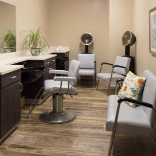 A modern hair salon interior with styling chairs, mirrors, and a comfortable waiting area.