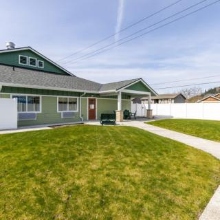 A suburban house with a well-maintained lawn and a fenced yard.
