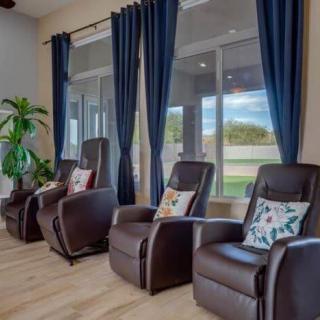 A modern living room with comfortable recliner chairs and large windows.