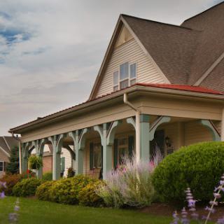 A charming house with a well-maintained porch and garden, showcasing beautiful architectural details.
