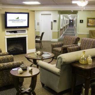 A cozy lounge area with comfortable seating, a fireplace, and a television.