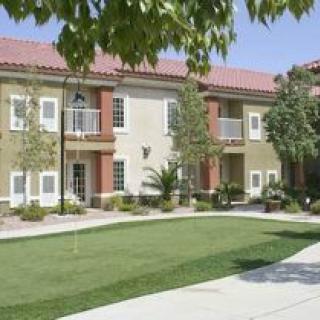 A residential apartment building with a neatly maintained lawn and surrounding greenery.