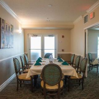A formal dining room with a neatly set table surrounded by elegant chairs.