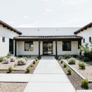 A serene modern courtyard with elegant landscaping and a welcoming entrance.