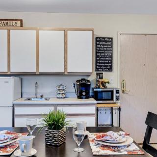 A cozy kitchen and dining area featuring a well-set table, white cabinets, and modern appliances.
