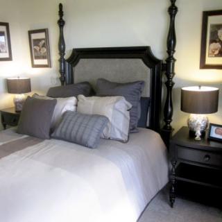 A cozy bedroom with a dark wooden bed frame and stylish decor.