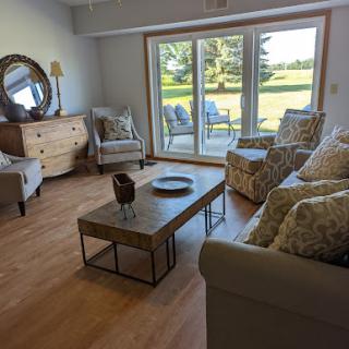 A bright and inviting living room featuring comfortable sofas, a stylish coffee table, and large sliding doors that open to a beautiful outdoor view.