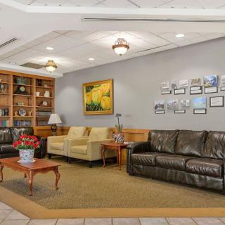 A cozy lobby with sofas, artwork on the wall, and a wooden bookshelf.
