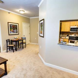 A cozy apartment interior featuring a small dining area and a view into the kitchen.