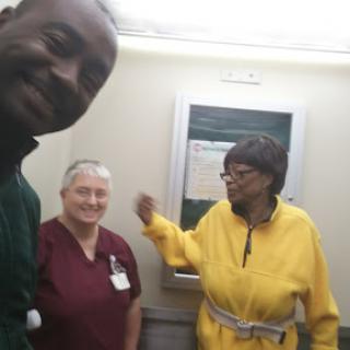 A joyful moment captured inside a hospital elevator with staff and a patient.