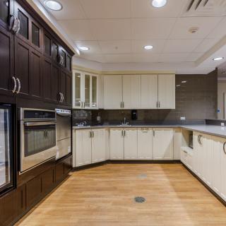 A modern kitchen with sleek cabinetry and wood flooring.