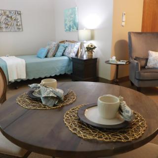 A cozy living space featuring a dining area and a bed in a modern interior design.