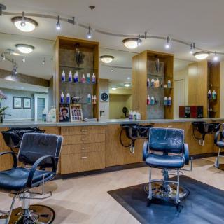 A modern hair salon interior featuring stylish chairs and well-lit mirrors.