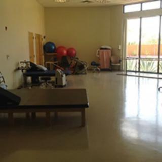 A physical therapy room equipped with exercise tables and gym equipment.
