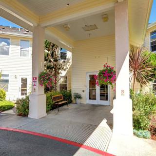 The entrance of a building featuring decorative potted plants and flowers.