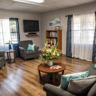 A cozy living room adorned with comfortable seating, a vibrant floral arrangement, and ample natural light.
