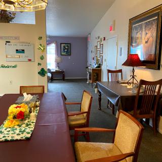 A cozy dining area featuring a long table with chairs, decorative elements, and warm lighting.