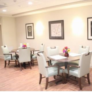 A cozy and elegantly designed dining area featuring stylish tables and chairs with floral decorations.