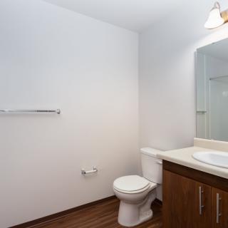 A minimalist bathroom with a toilet, sink, and mirror.
