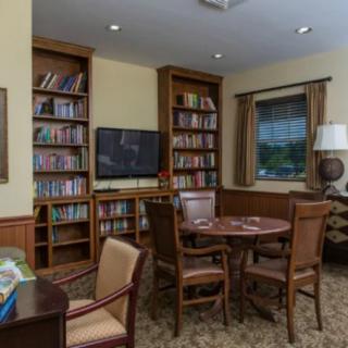 A cozy library corner with bookshelves, a table, and chairs for reading.