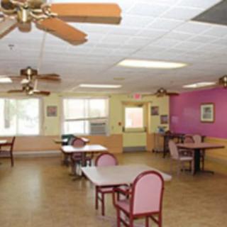 A spacious dining area with tables, chairs, and ceiling fans.