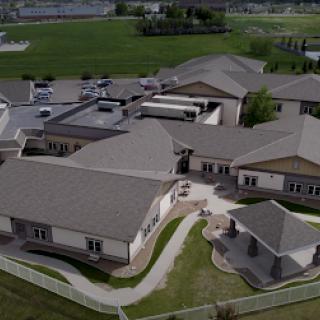 Aerial view of a modern community building surrounded by green landscapes.