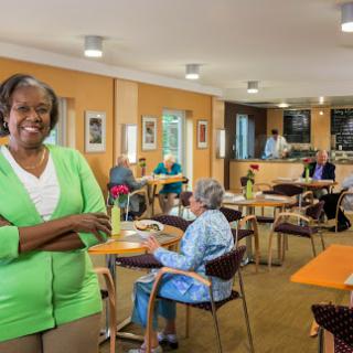 A joyful moment in a senior community center, highlighting the warm interaction between caregivers and residents.