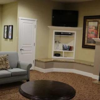 A cozy living room with a sofa, coffee table, and wall-mounted television.