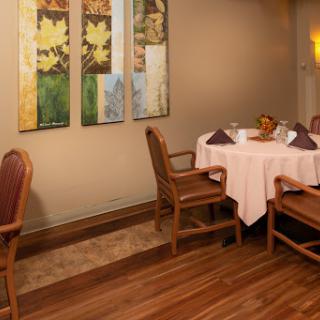 A cozy restaurant dining area featuring a neatly set table and elegant wall decor.