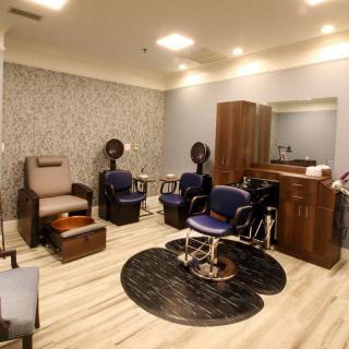 A cozy hair salon interior with chairs and a mirror.