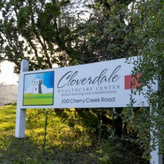 A sign for Cloverdale Visitor Center amidst a natural outdoor setting.