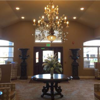 Elegant lobby with a chandelier and floral centerpiece on the table.