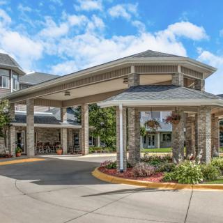A welcoming building entrance with a covered driveway and well-maintained landscaping.