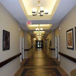 A well-lit interior hallway featuring decorative artwork and doors on either side.