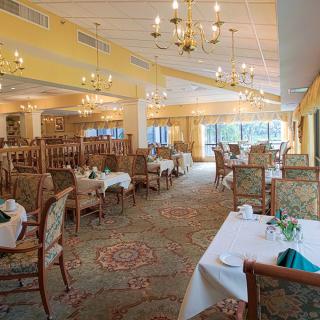 An elegant dining area featuring chandeliers and well-arranged tables.