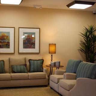 A cozy living room featuring comfortable sofas, decorative artwork, and a stylish lamp.