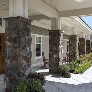 A building entrance with stone columns and landscaped surroundings.